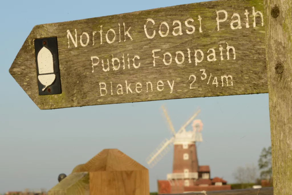 Norfolk Coast Footpath sign with windmill in the background