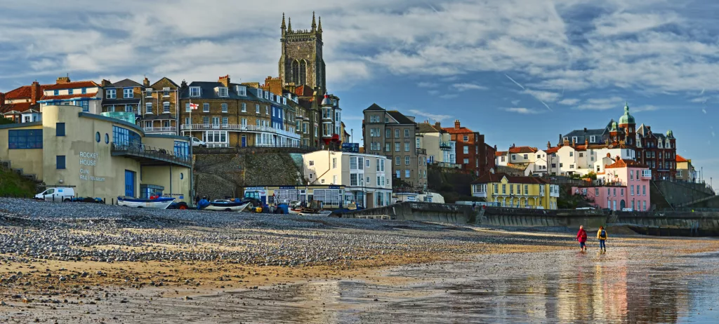 Panorama of Cromer beach, two people are walking in the foreground