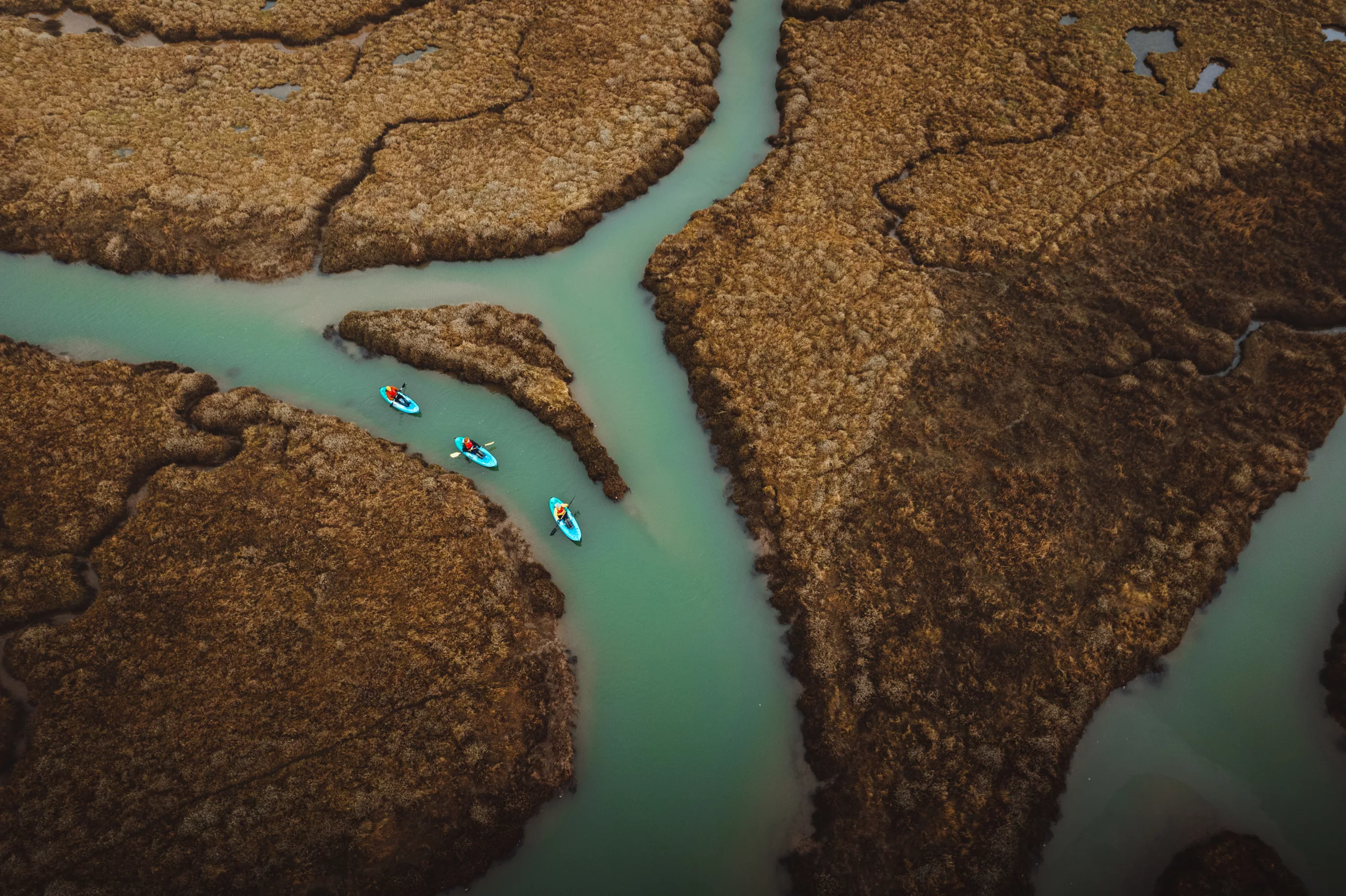 Aerial view of three people kayaking in Burnham Overy