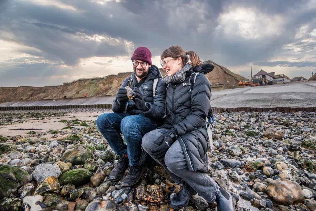 A couple looking at a fossil on West Runton beach