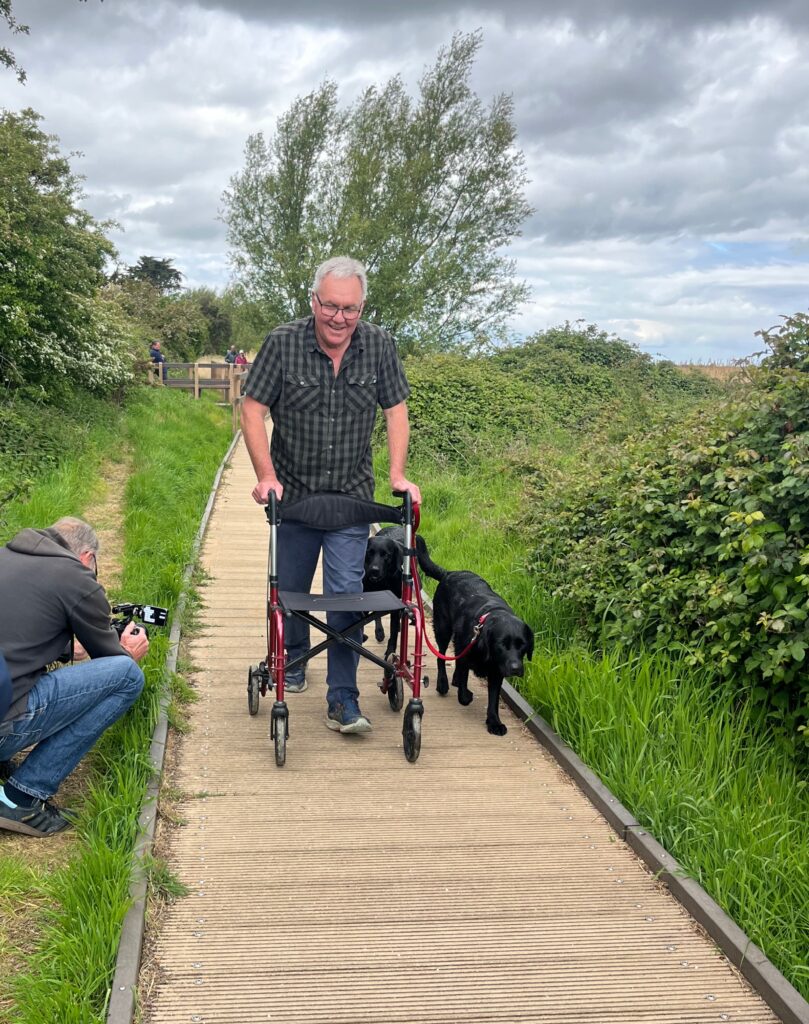Man using walker on Brancaster boardwalk